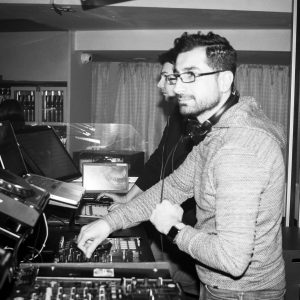 Schwarz-weiß Foto von DJ Gilano vor seinem DJ-Pult