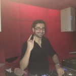 DJ Gilano bei der Arbeit, mit der rechten Hand formt er das Rock&Roll Zeichen