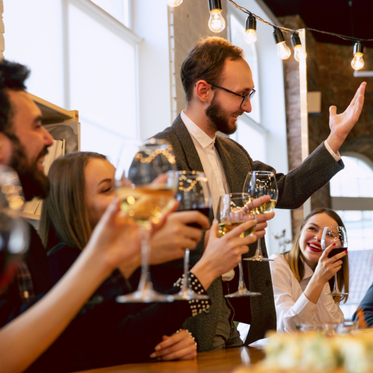 Vier Menschen erheben ihre Gläser zum Anstoßen